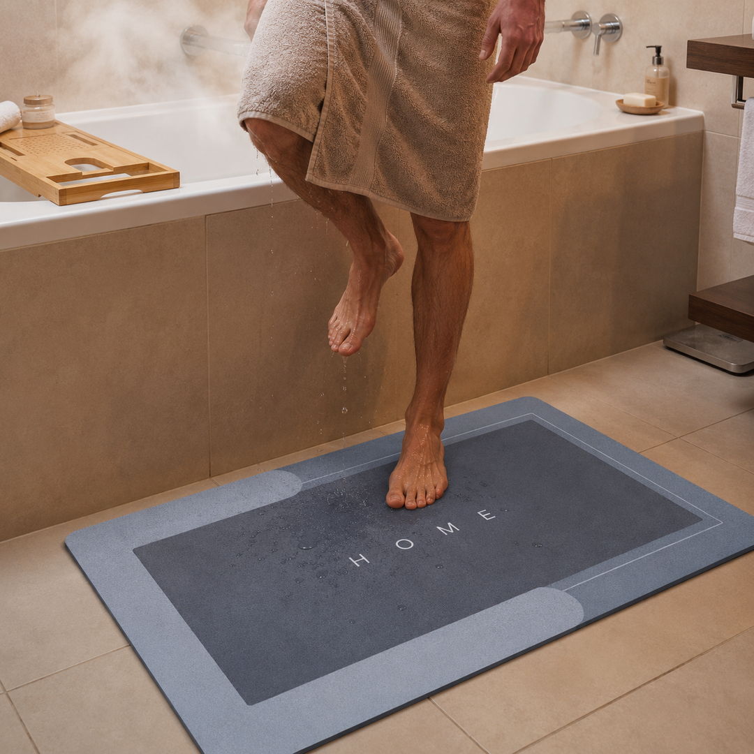 Person stepping onto a 'HOME' bath mat in a bathroom.